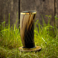 Bild in Galerie-Betrachter laden, Et højt, indviklet designet Drikkeglas Horn med mønster (300 ml) med en gylden kant, placeret på en træskranke, er placeret på levende grønt græs. Baggrunden har en rustik trævæg.