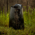 Bild in Galerie-Betrachter laden, Vikingekrus Thors Hammer Horn (600-800 ml), et poleret sort hornkrus med et ætset design af Thors Hammer, vises på levende grønt græs mod en rustik træbaggrund.