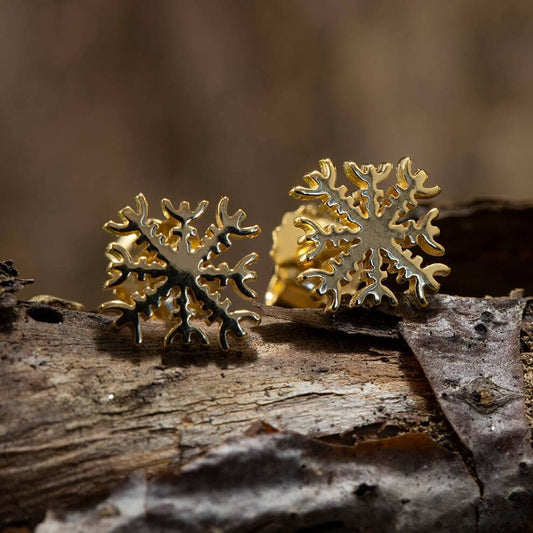 Ørestikker Amulet Ægirs Hjelm i forgyldt 925s Sterling Sølv vises yndefuldt på en ru, naturlig træbark med en sløret baggrund, hvilket fremhæver deres indviklede design og glans.